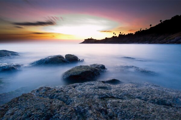Каменистый берег моря на закате