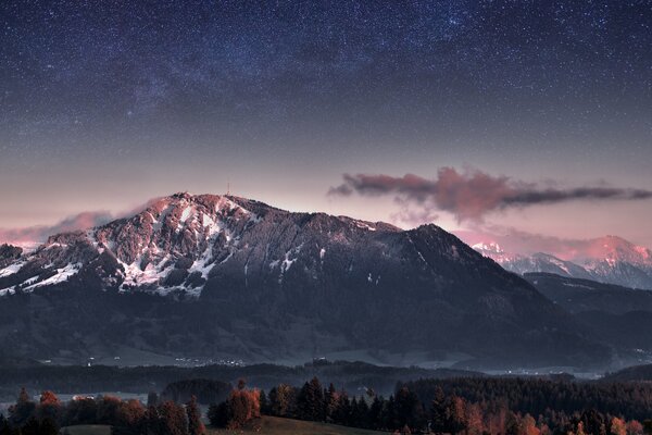 The Milky Way and mountains are visible in the sky