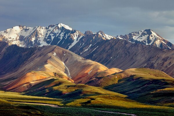 Snow-capped mountains and a valley with hills