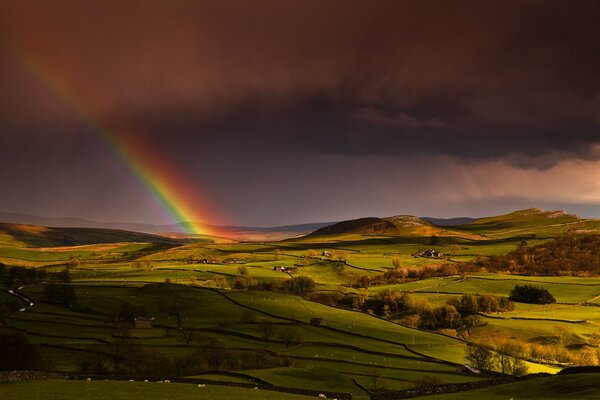 Rainbow in the sky and green hills