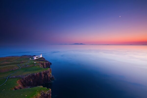 Il faro sulla roccia al tramonto sembra misterioso