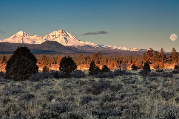 Mountain peaks against the sky. Full moon in the desert