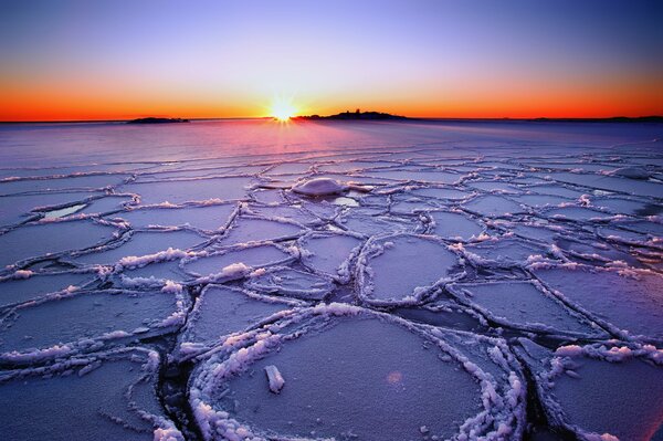 A charming sunset on the shore of a winter lake