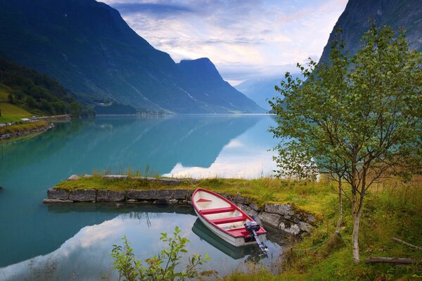 Miroir surface du lac dans les montagnes. Bateau à moteur au large de la côte