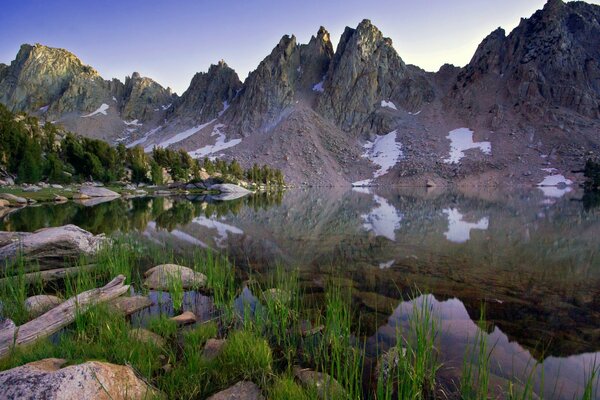 Montañas con vegetación junto al lago y la hierba