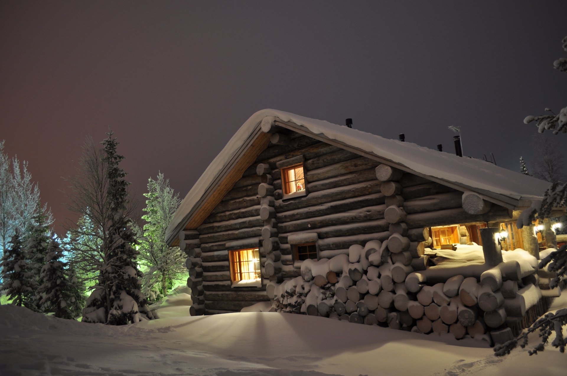 hiver neige congères rondins maison chalet bois de chauffage nuit sapins