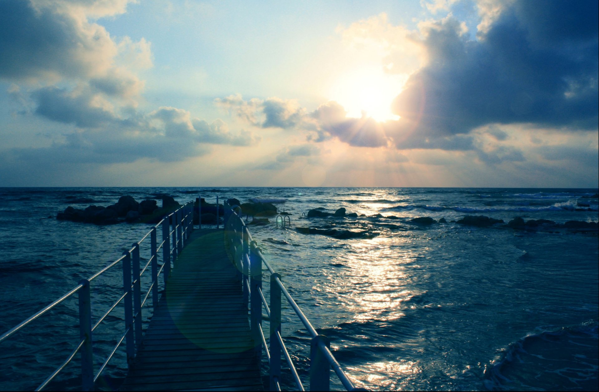 paisaje mar olas piedras muelle cielo sol nubes rayos fondo de pantalla