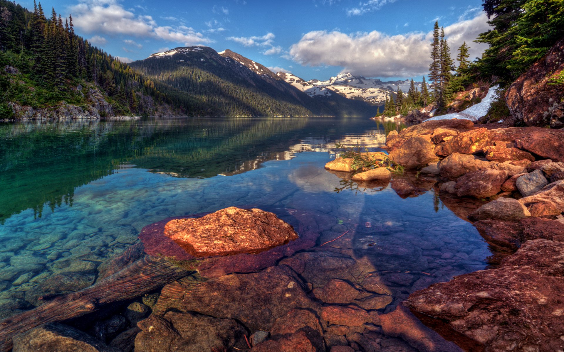 landscape sky clouds snow mountain rock slope forest tree christmas tree water stones reflection lake garibaldi canada