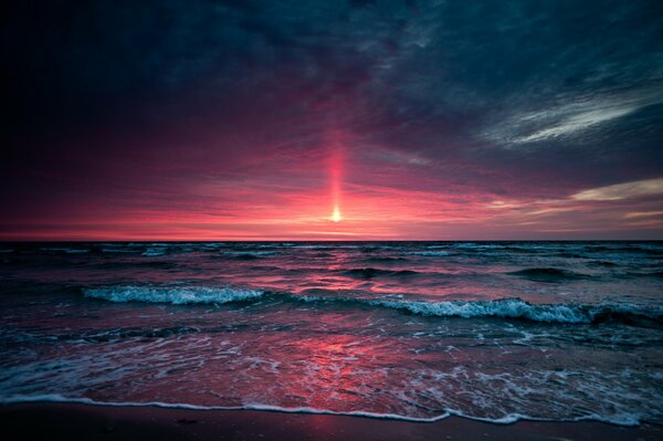 Puesta de sol roja en las olas del mar