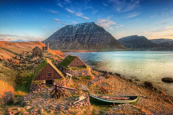 Casas en la costa de Islandia. Montañas en el horizonte