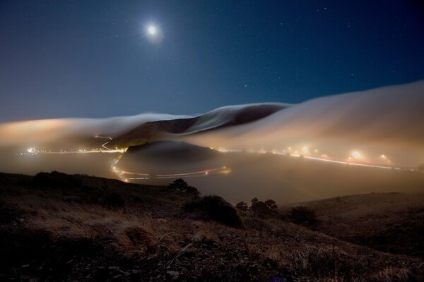 Bruma y luces se precipitan en el cielo de la niebla