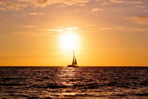 The yacht is sailing on the sunset horizon