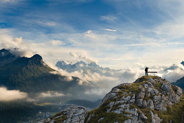 Imagen panorámica de un hombre en el fondo de nubes y montañas