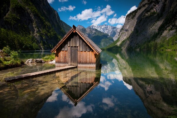 Casa junto al lago con puente en las montañas