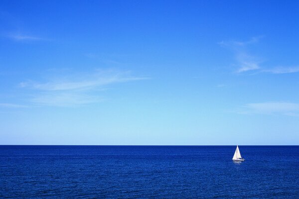 Vela blanca contra el mar azul y el cielo
