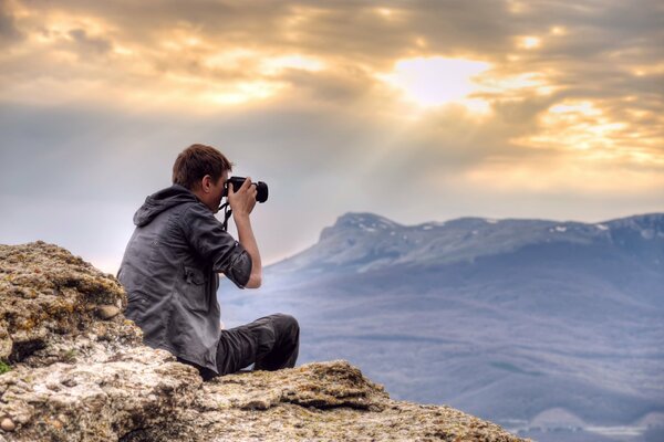 A photographer at a height photographs mountains