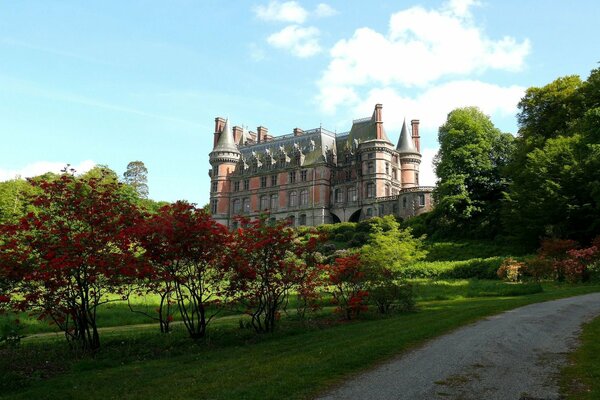 Un antiguo castillo rodeado de exuberante vegetación en un día soleado