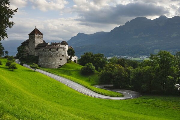 Ein altes Schloss auf einem grünen Hügel