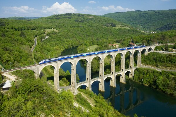 Blue train rushing across the French bridge