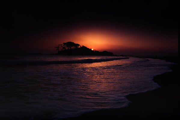 Мрачный закат у моря с тенями от островка