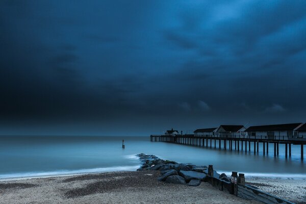 Twilight Pier on the background of dark parties