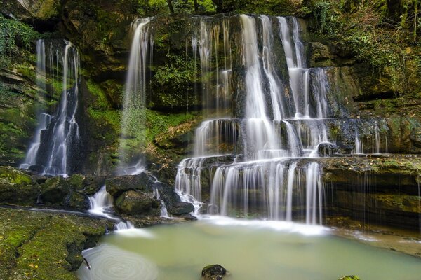 Hermosa cascada se derrama sobre las piedras