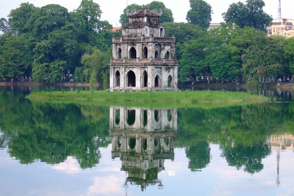 Old building on the island, reflection in the water