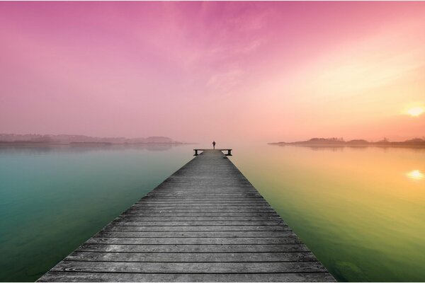 Muelle del lago que conduce al amanecer rosado