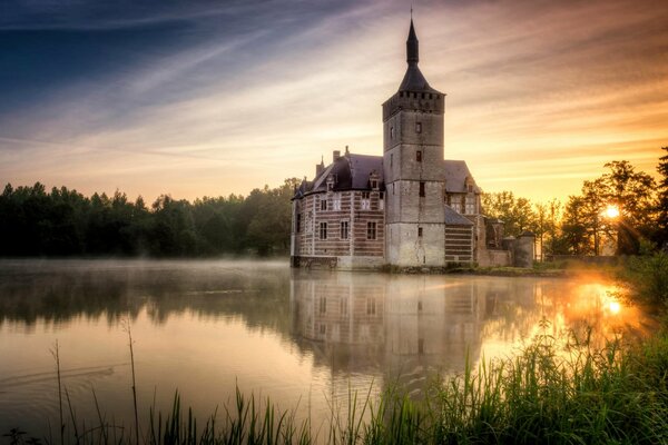 Château de Horst sur un lac en Belgique au coucher du soleil