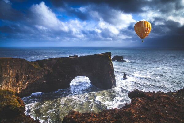 Fotograf andrés nieto porras uchwycił balon przy skałach w oceanie