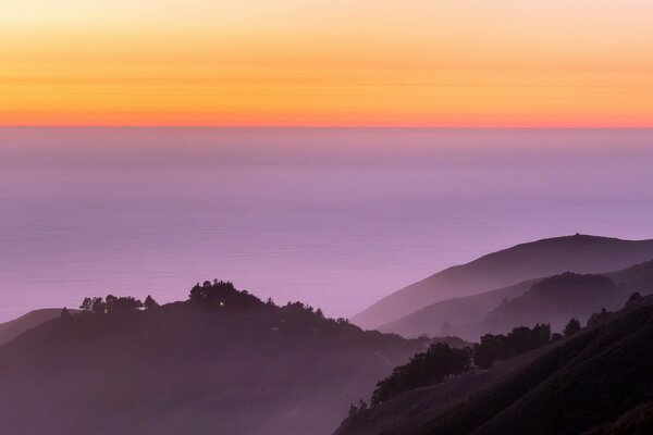 Contraste de colinas moradas y puesta de sol naranja