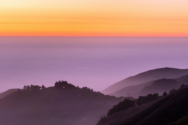 Contrasto di colline viola e tramonto arancione