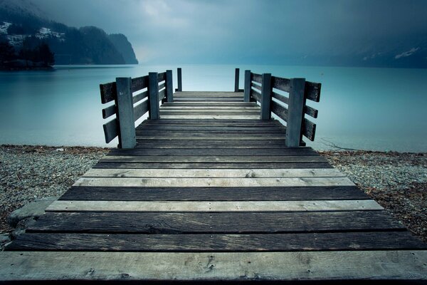 Depression, gray landscape and pier over the lake