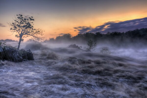 Niebla embriagadora con una hermosa puesta de sol en el río