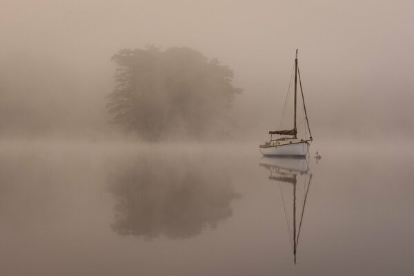 Yacht in the fog of the morning lake