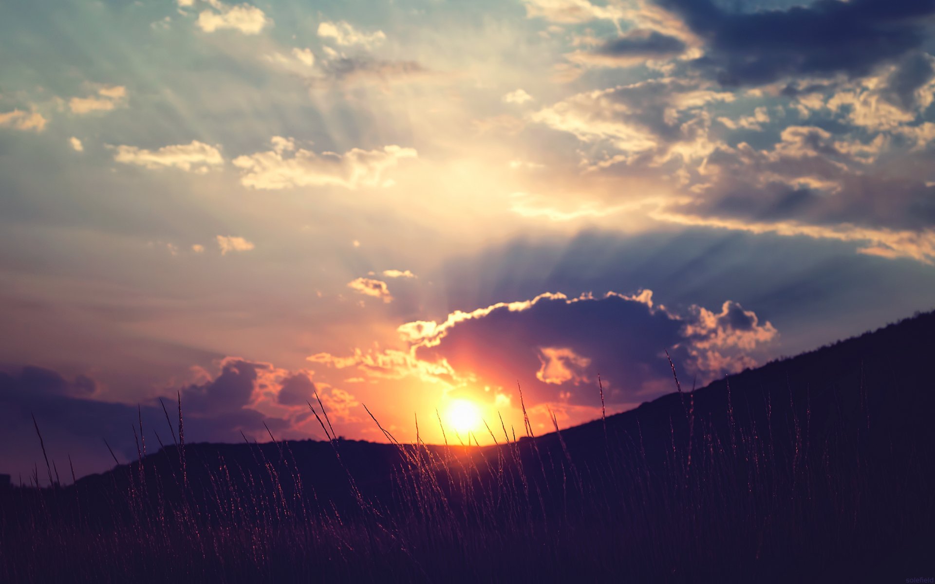 unset sun rays clouds sky hills gra