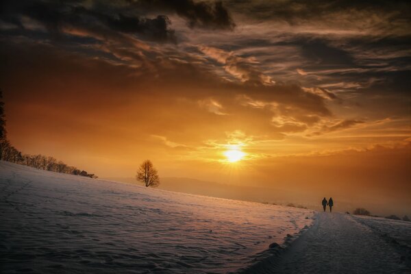 Menschen, die vor dem Hintergrund des Sonnenuntergangs gehen