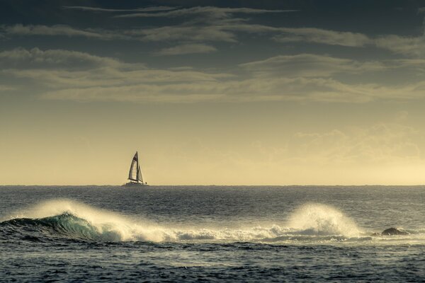 Voile blanche solitaire dans le brouillard bleu de la mer