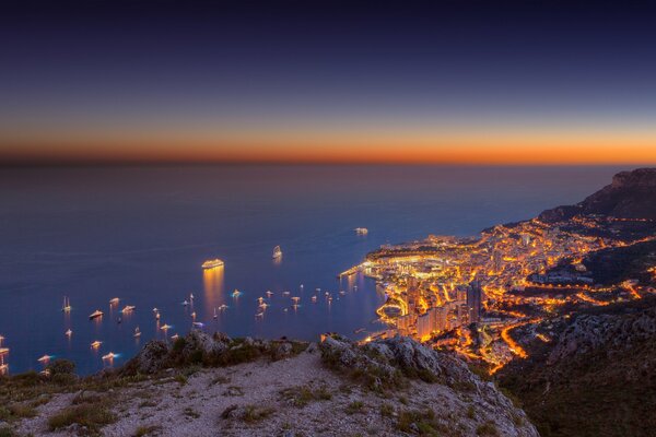 Yates en el fondo de la puesta de sol en la costa de Monte Carlo