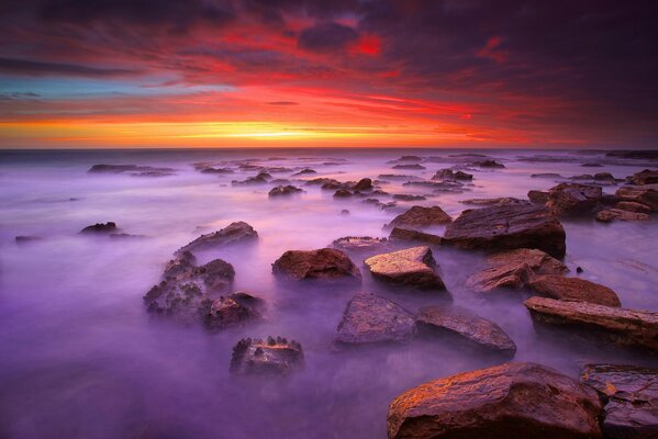 Brumoso amanecer en el mar donde yacen las piedras