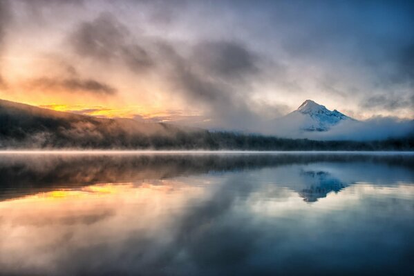 Утренний туманна озере на фоне гор