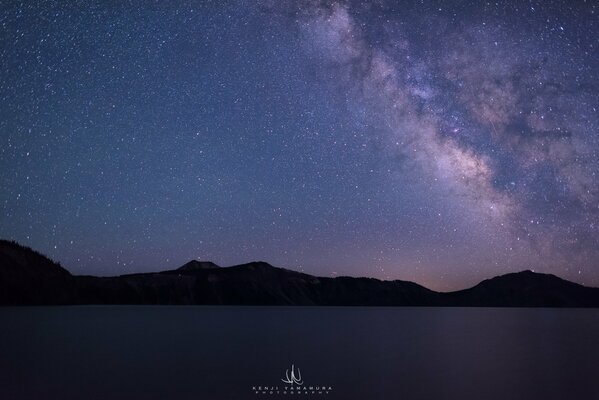 Lago nocturno contra el cielo estrellado
