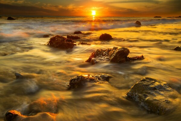 Zachód słońca na kamiennej plaży Malibu