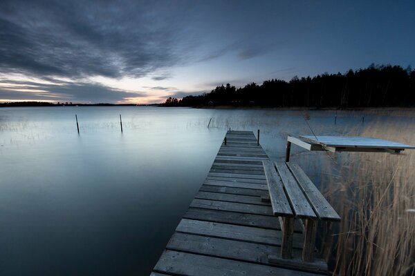 A bridge with a bench across a lake in Sweden