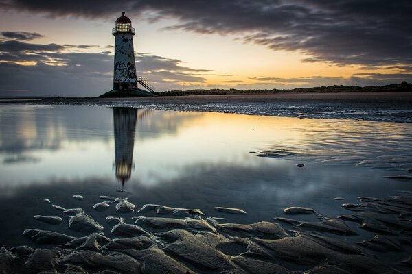 High lighthouse on the background of dawn