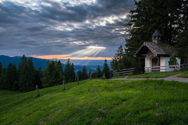 Piccola cappella vicino alle montagne con foresta