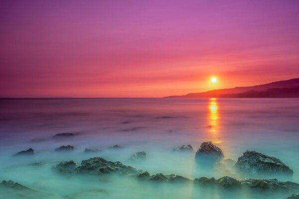 Alba sull oceano con le rocce