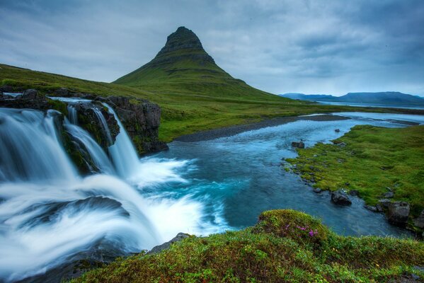 Górski wodospad z wulkanem w parku Islandii