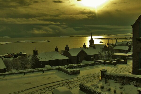 Winter sunset over the snow-covered roofs of houses