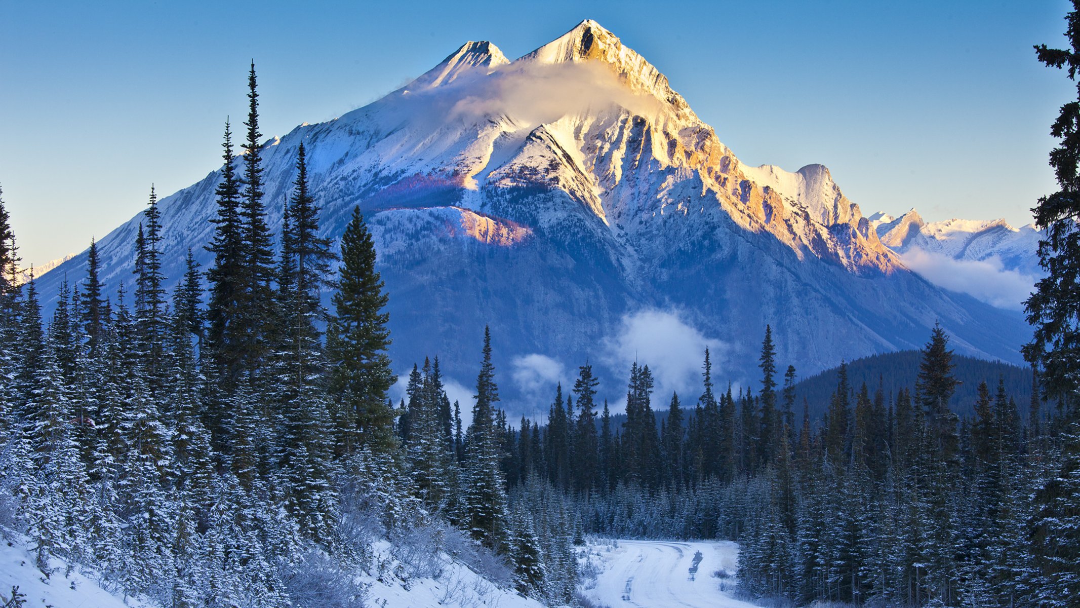 alberta banff national park kanada himmel berge bäume schnee fichte hang sonnenuntergang straße